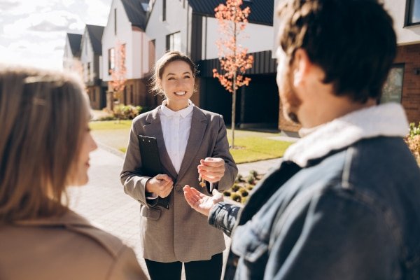 AdobeStock_1838553388 - Residential Conveyancing Section-600 Happy clients receiving the keys to their new home — residential conveyancing by Fords Daly Legal in Kirkcaldy